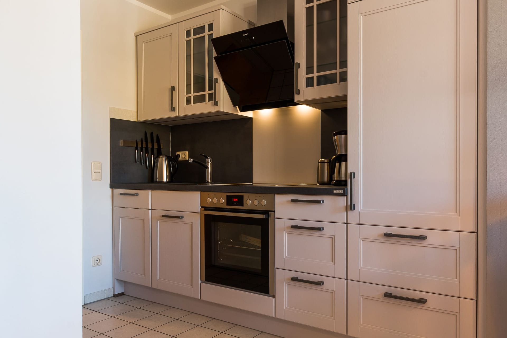 Moderne Küche mit Kochfeld und Backofen.