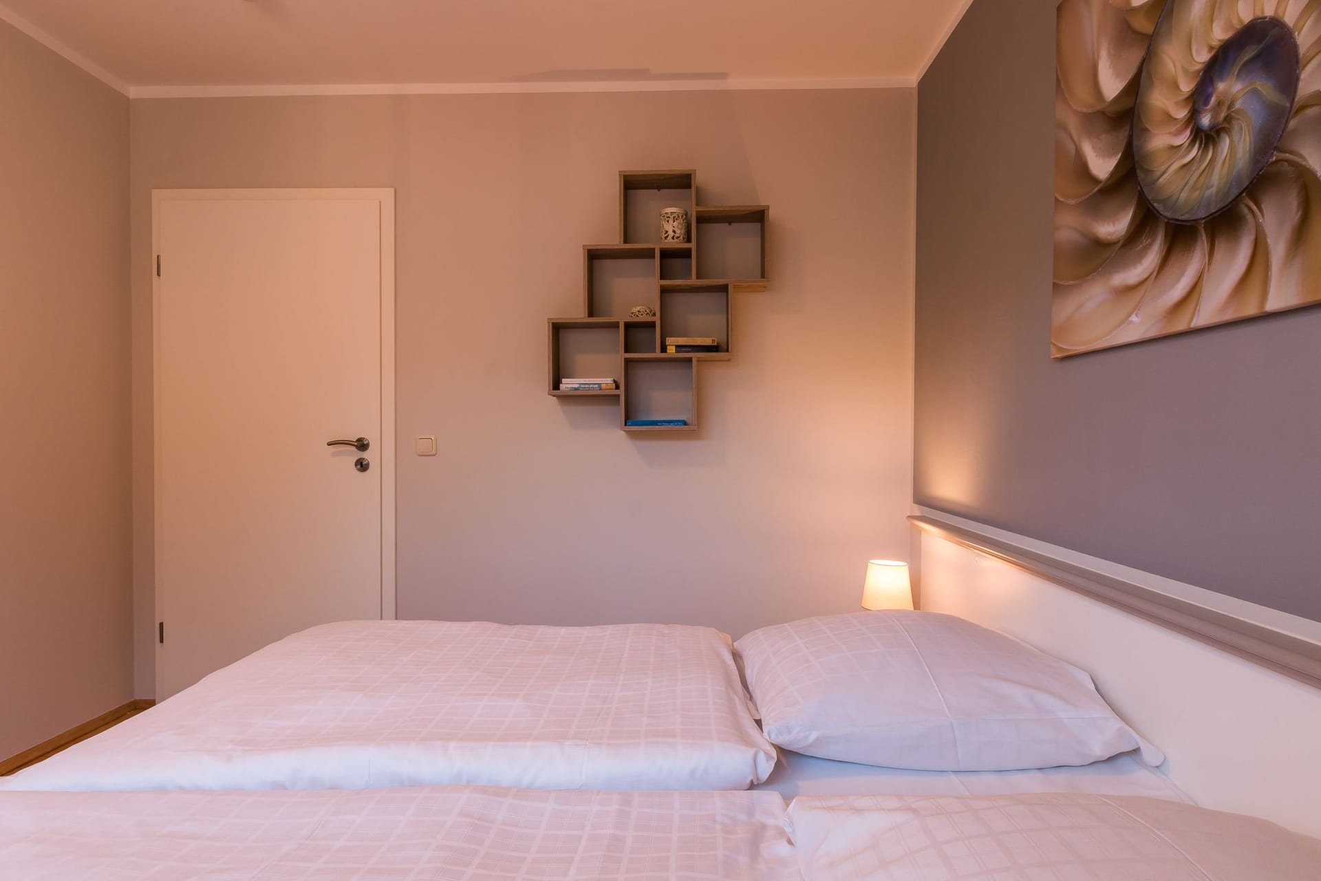 Schlafzimmer mit Doppelbett und Wandregal
