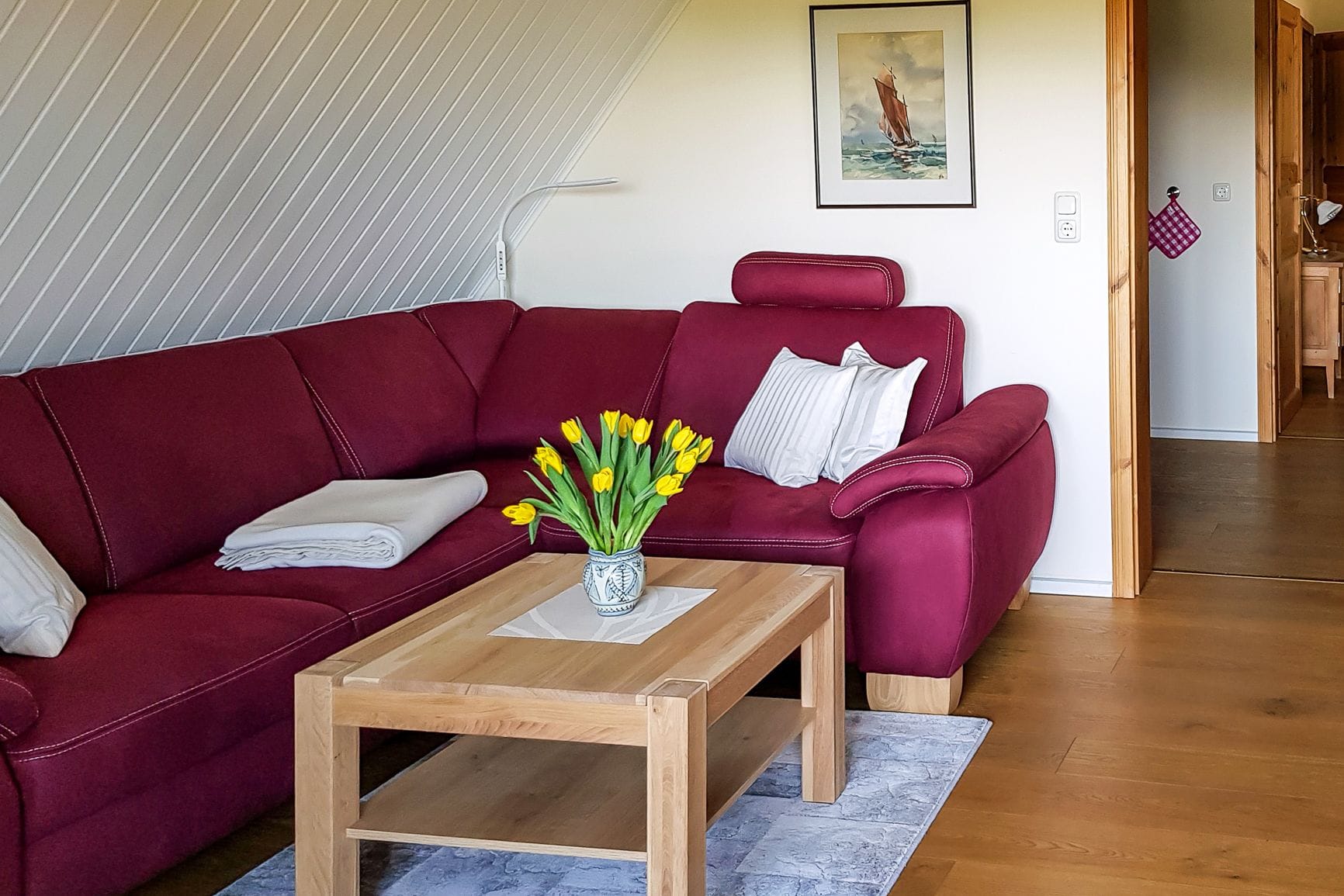 Wohnzimmer mit rotem Sofa und Holztisch