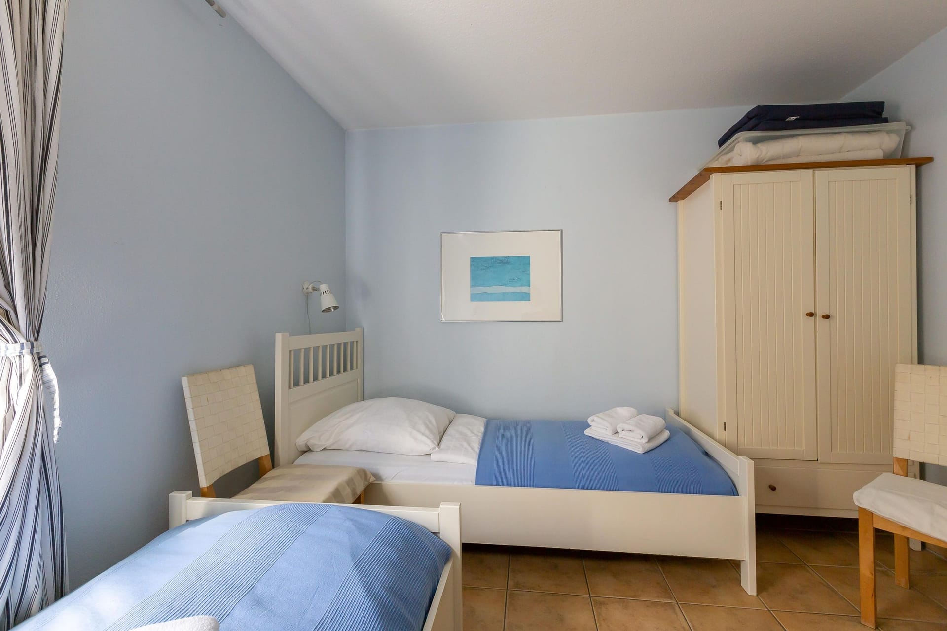 Gemütliches Schlafzimmer mit zwei Betten und Kleiderschrank.