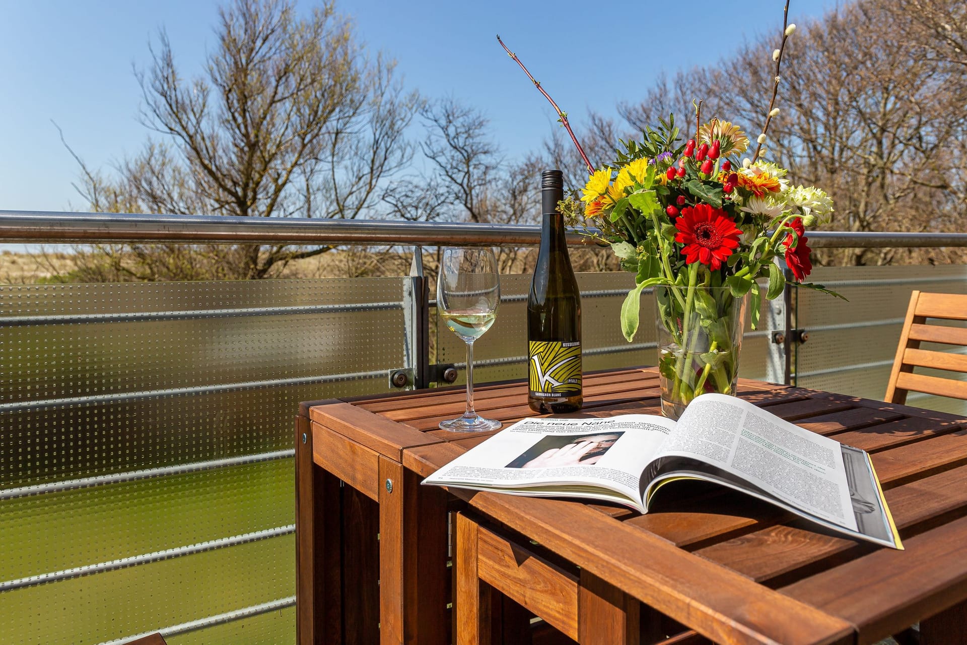 Balkon mit Tisch, Blumen und Blick ins Grüne