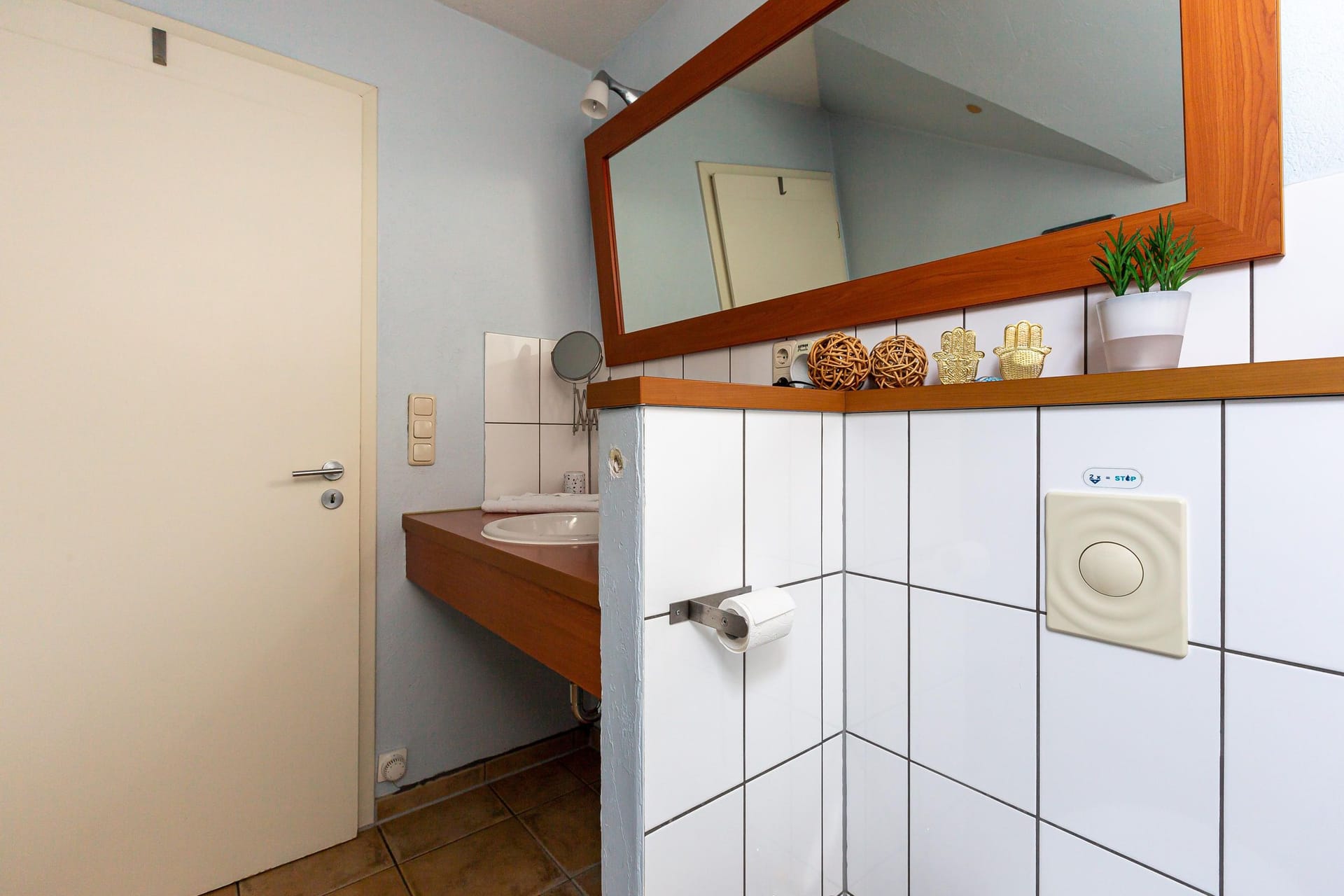 Helles Badezimmer mit Holzwaschbecken und Spiegel