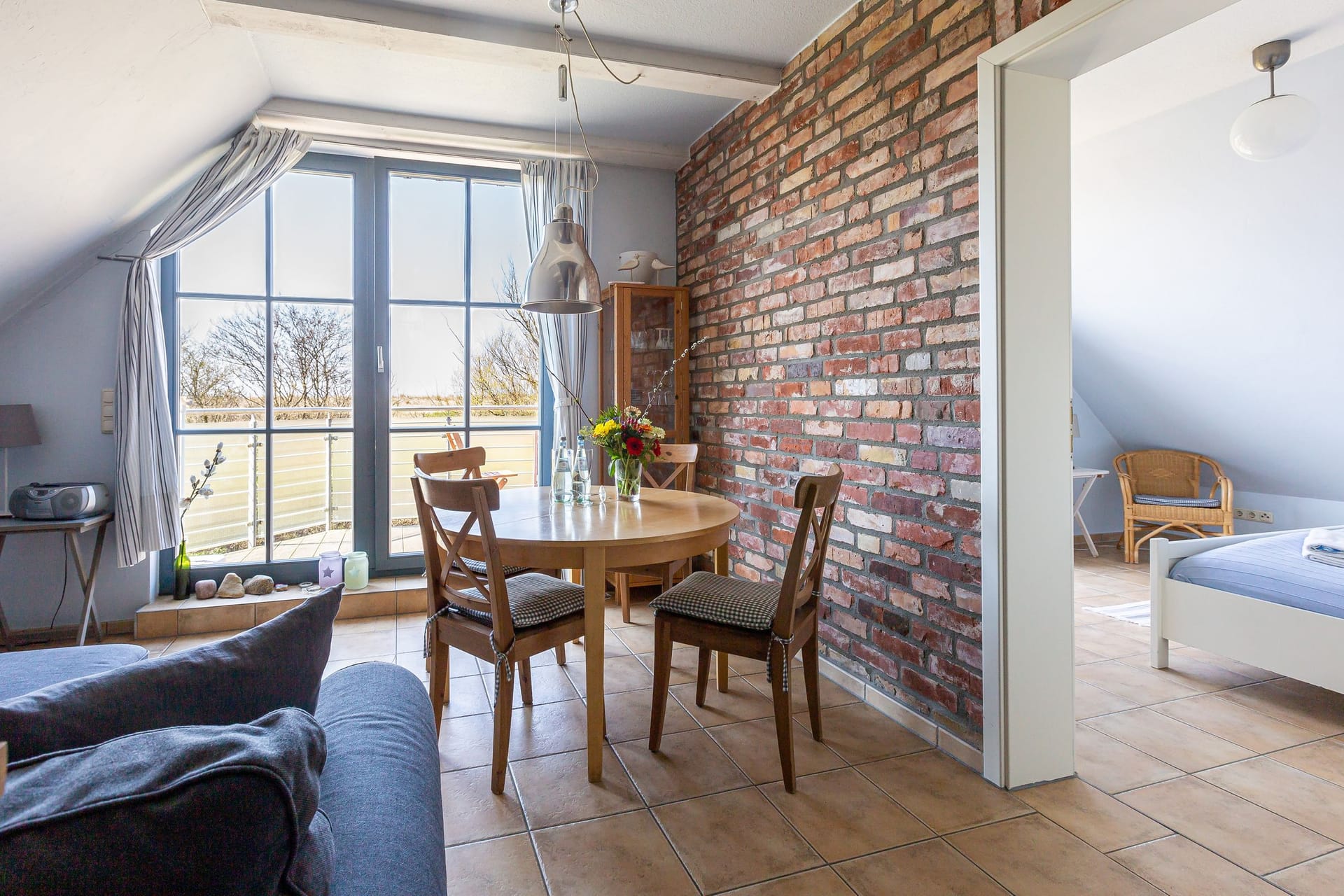 Wohnzimmer mit Esstisch und Balkonblick