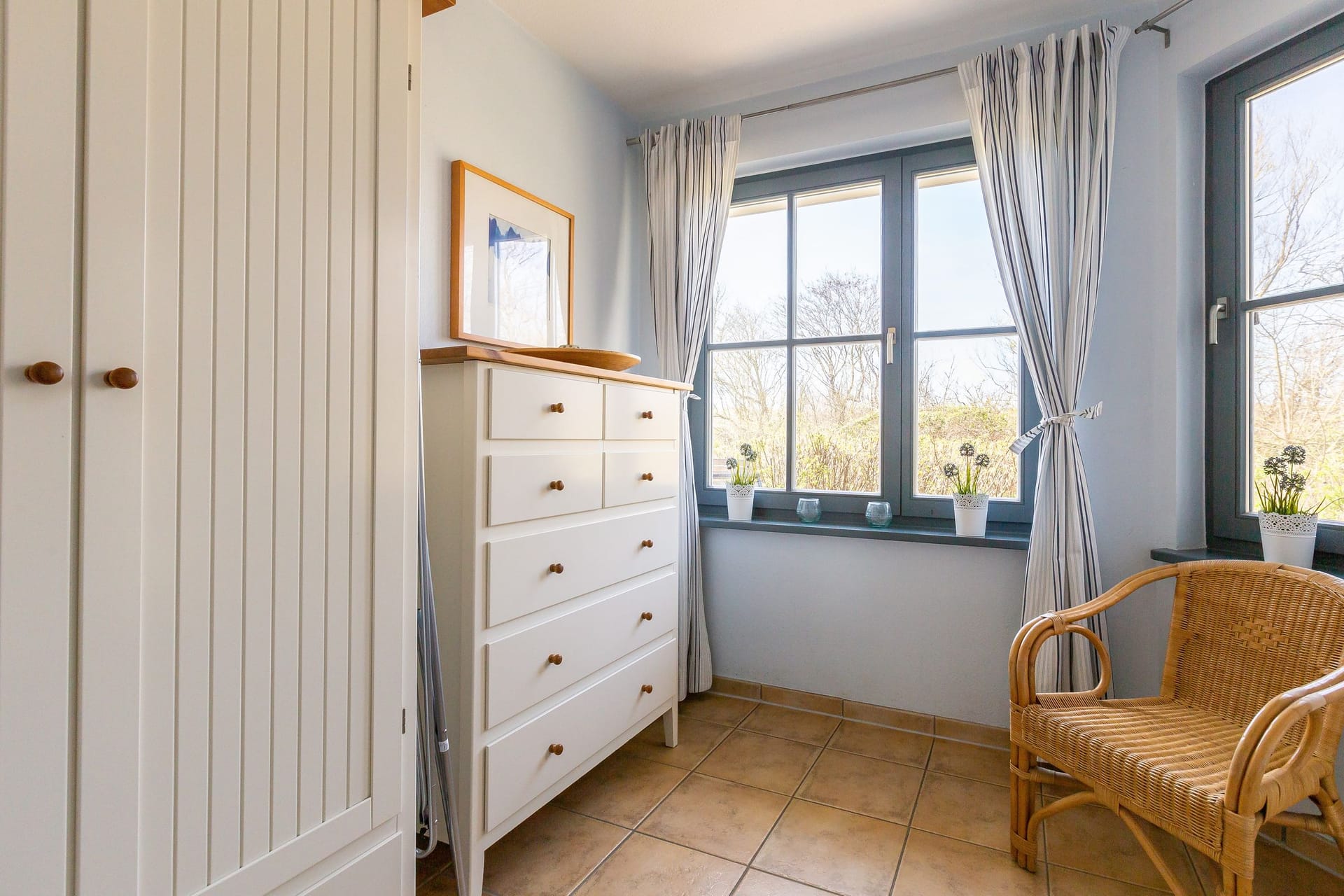 Helles Schlafzimmer mit Kommode und Sessel