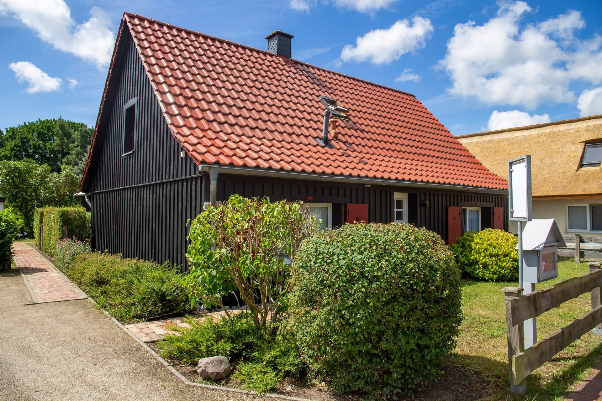 Einfamilienhaus mit rotem Ziegeldach und Garten