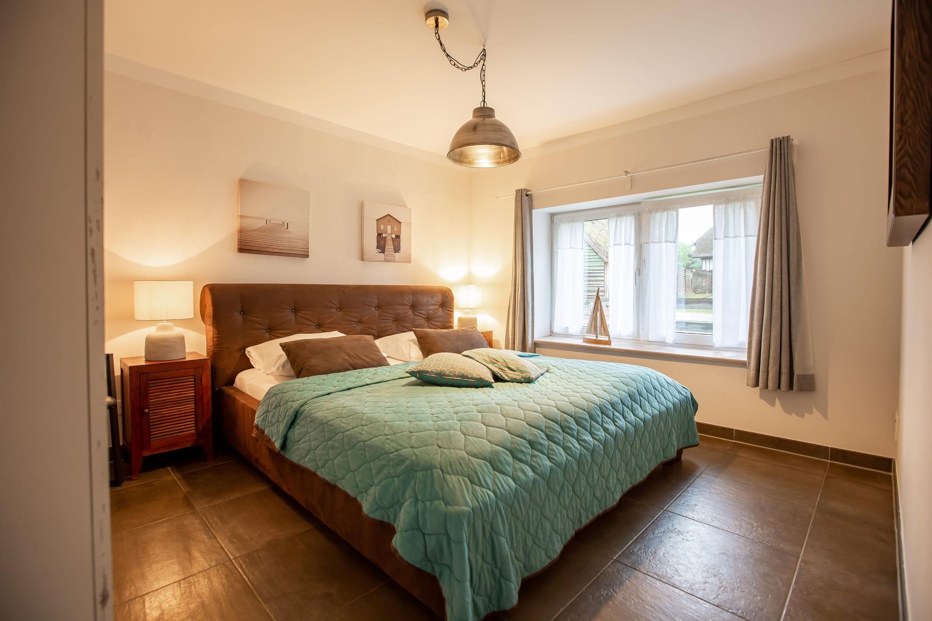 Helles Schlafzimmer mit Boxspringbett und Fenster