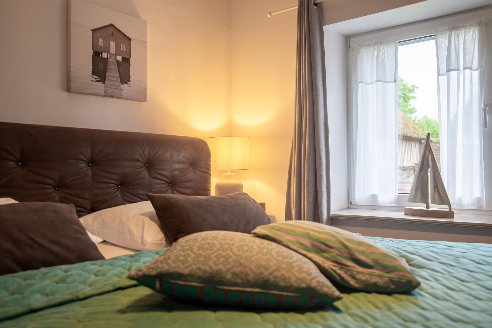 Schlafzimmer mit großem Bett und dekorativen Kissen