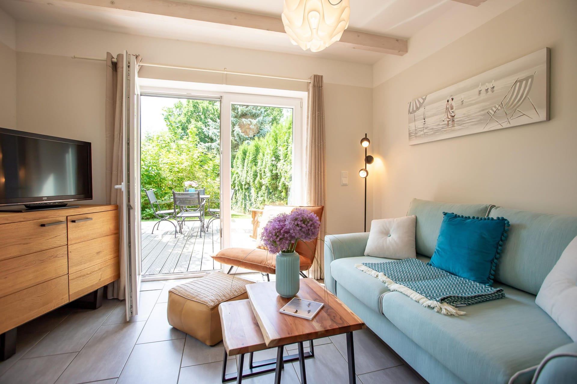 Helles Wohnzimmer mit Sofa und Blick auf den Garten