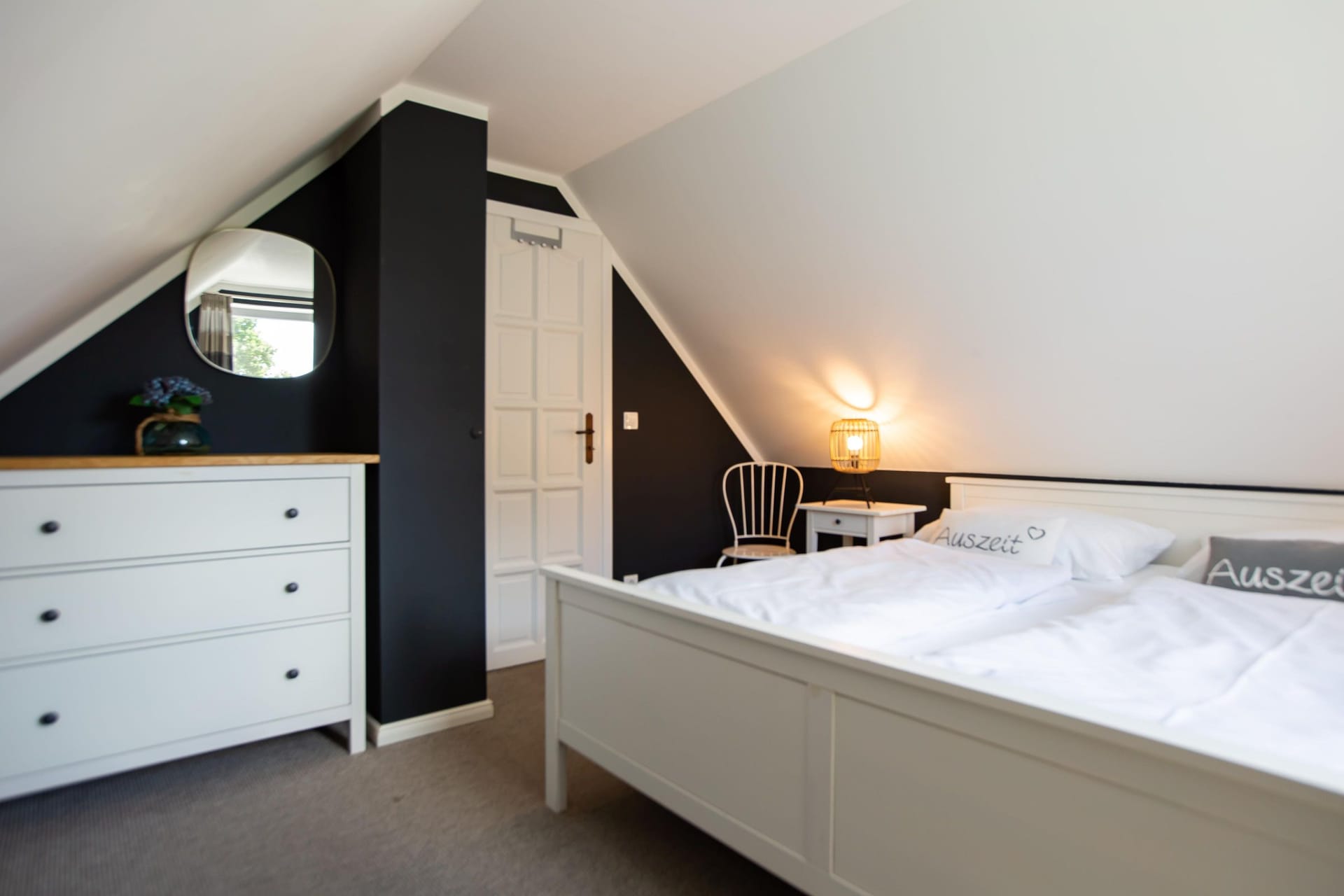 Schlafzimmer mit gemütlichem Doppelbett und Kommode