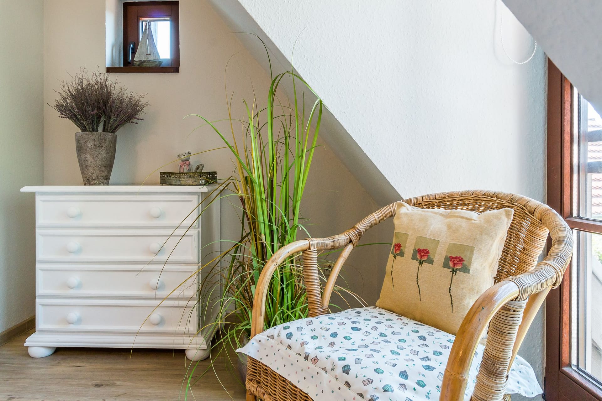 Heller Wohnbereich mit Rattanstuhl und Schrank