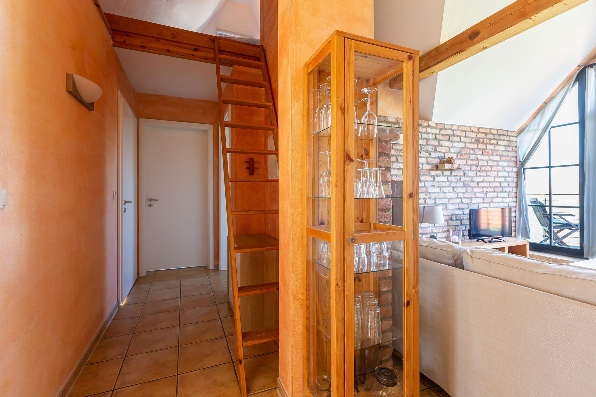 Heller Wohnraum mit Treppe und Glaskasten