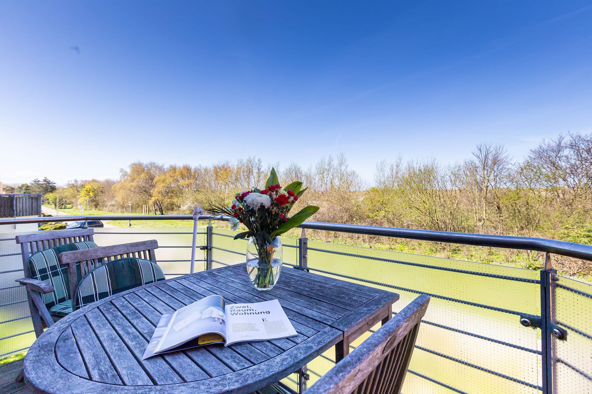 Terrasse mit Tisch und Blumenarrangement