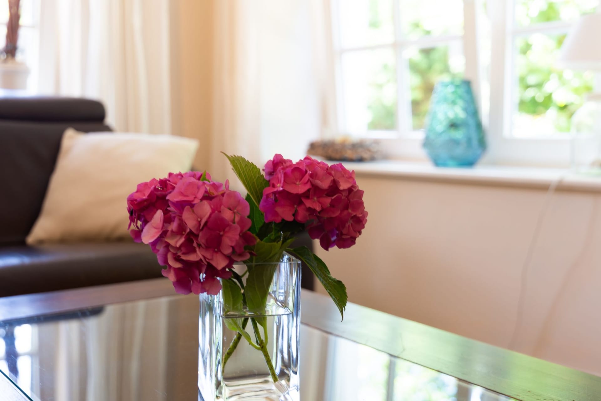 Einladender Wohnbereich mit Glastisch und Blumen