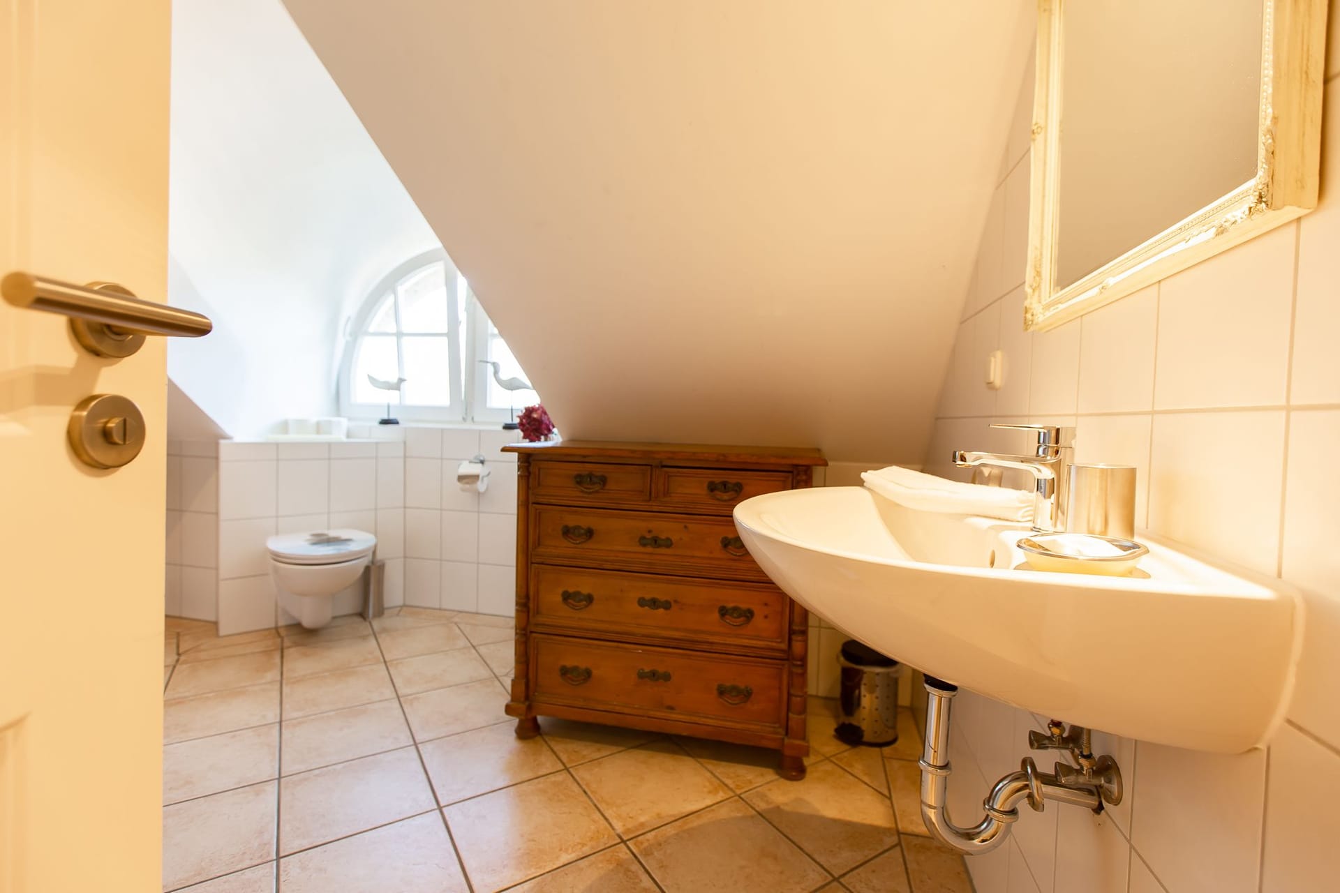 Helles Badezimmer mit Waschbecken und Holzkommode