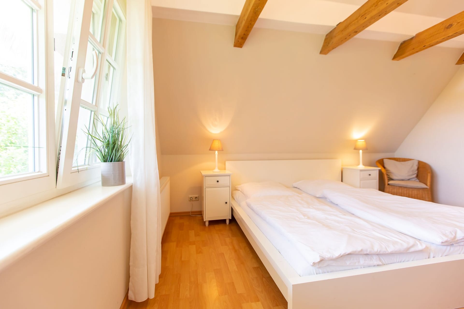 Helles Schlafzimmer mit Doppelbett und Stuhl