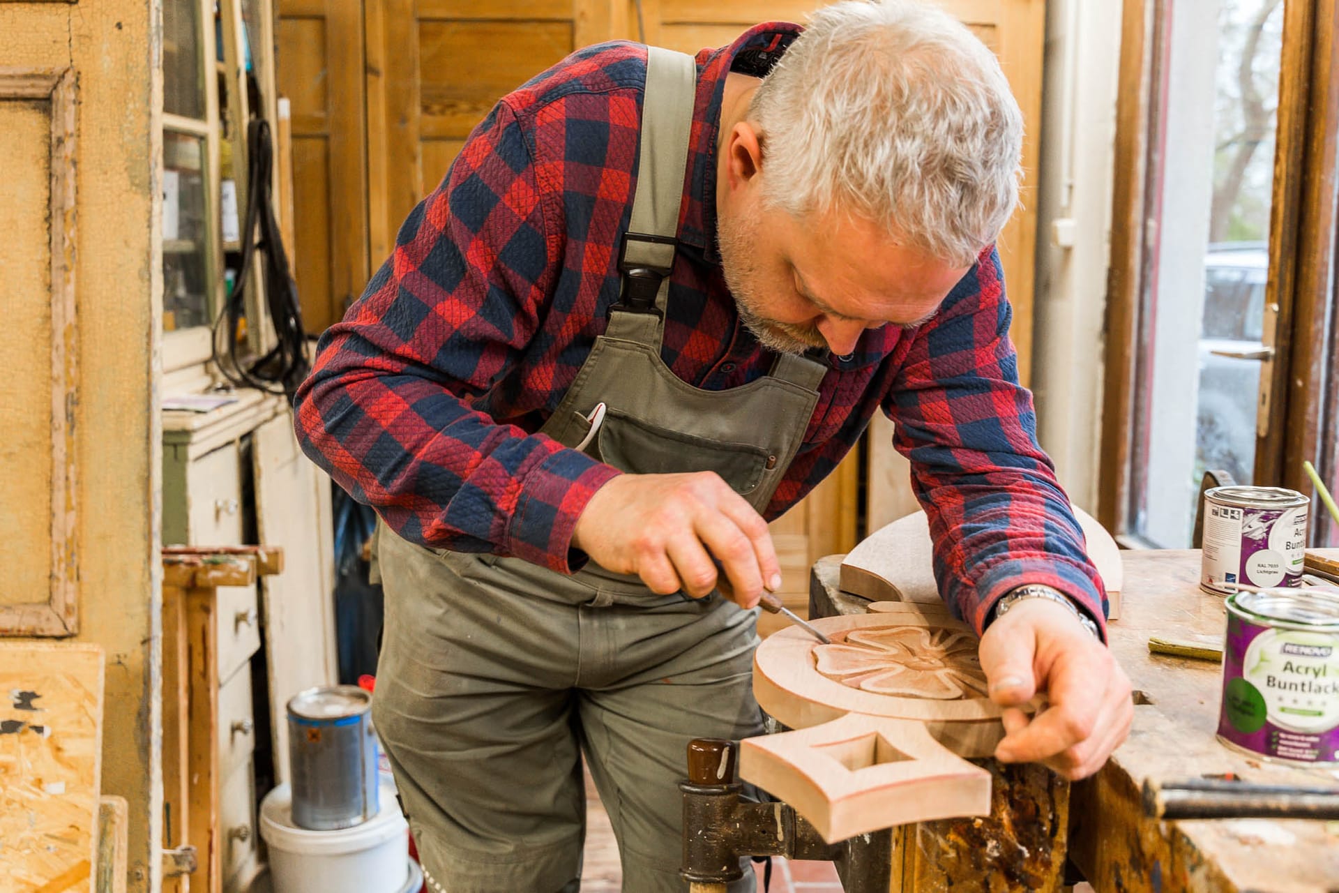 Die Person verwendet ein Werkzeug wie einen Hobel oder eine Raspel , um das Holz zu formen oder zu glätten.