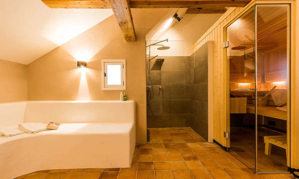 Saunaraum: links Sitzgelegenheit, in der Mitte Dusche, rechts Saunaeingang.