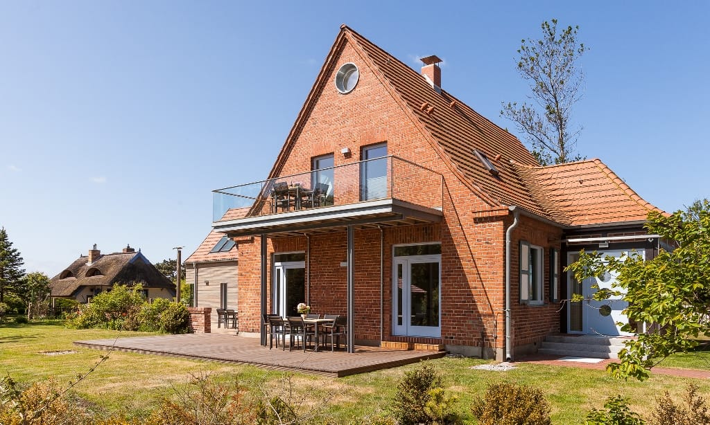 Haus aus rotem Backstein, Balkon/Terrasse, Eingangsbereich und Garten.