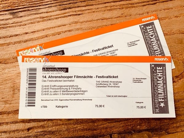 Zwei Festivaltickets für die „14. Ahrenshooper Filmnächte“ auf einer Holzoberfläche.