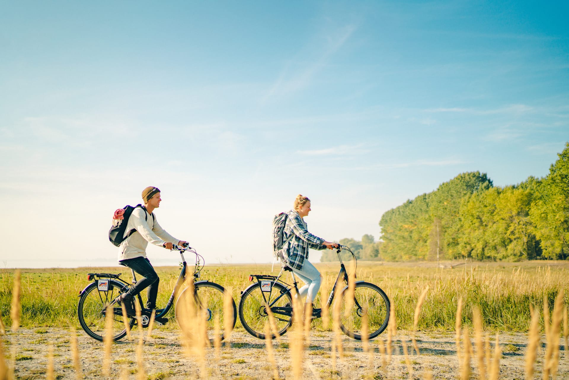 Zwei Radfahrer fahren durch die grüne Landschaft.