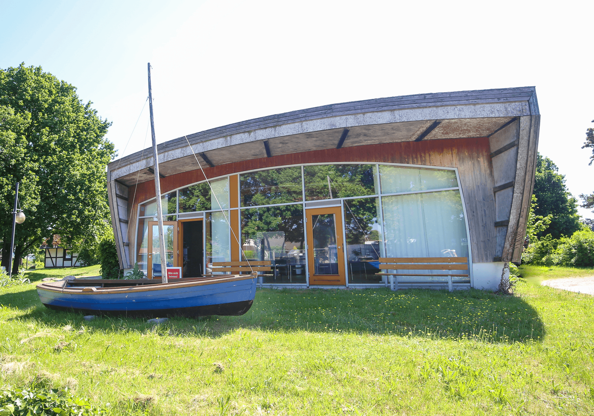 Moderne Darßer Arche mit Holzfassade und Boot davor
