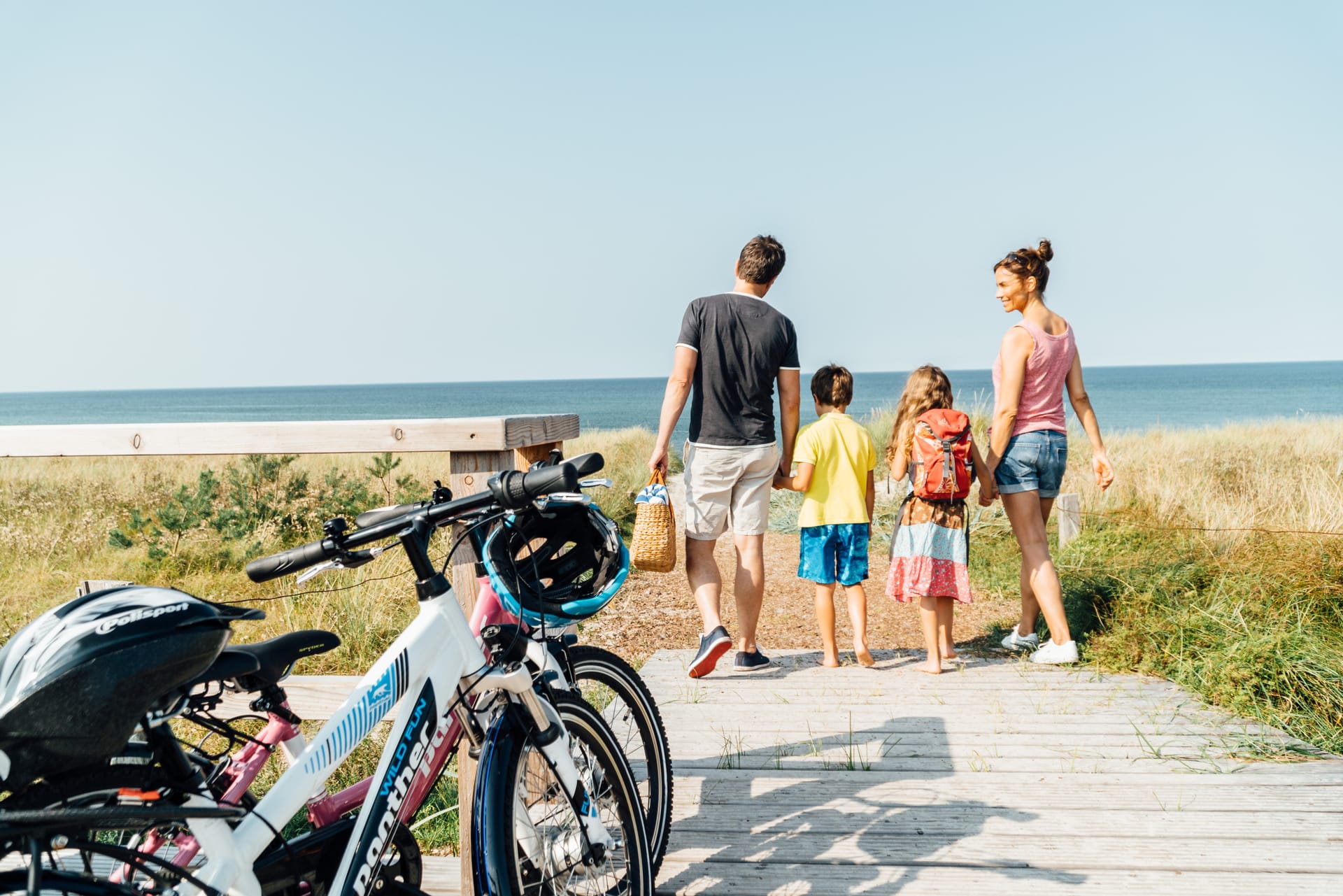 Familie mit Fahrrädern auf dem Weg zum Ostseestrand