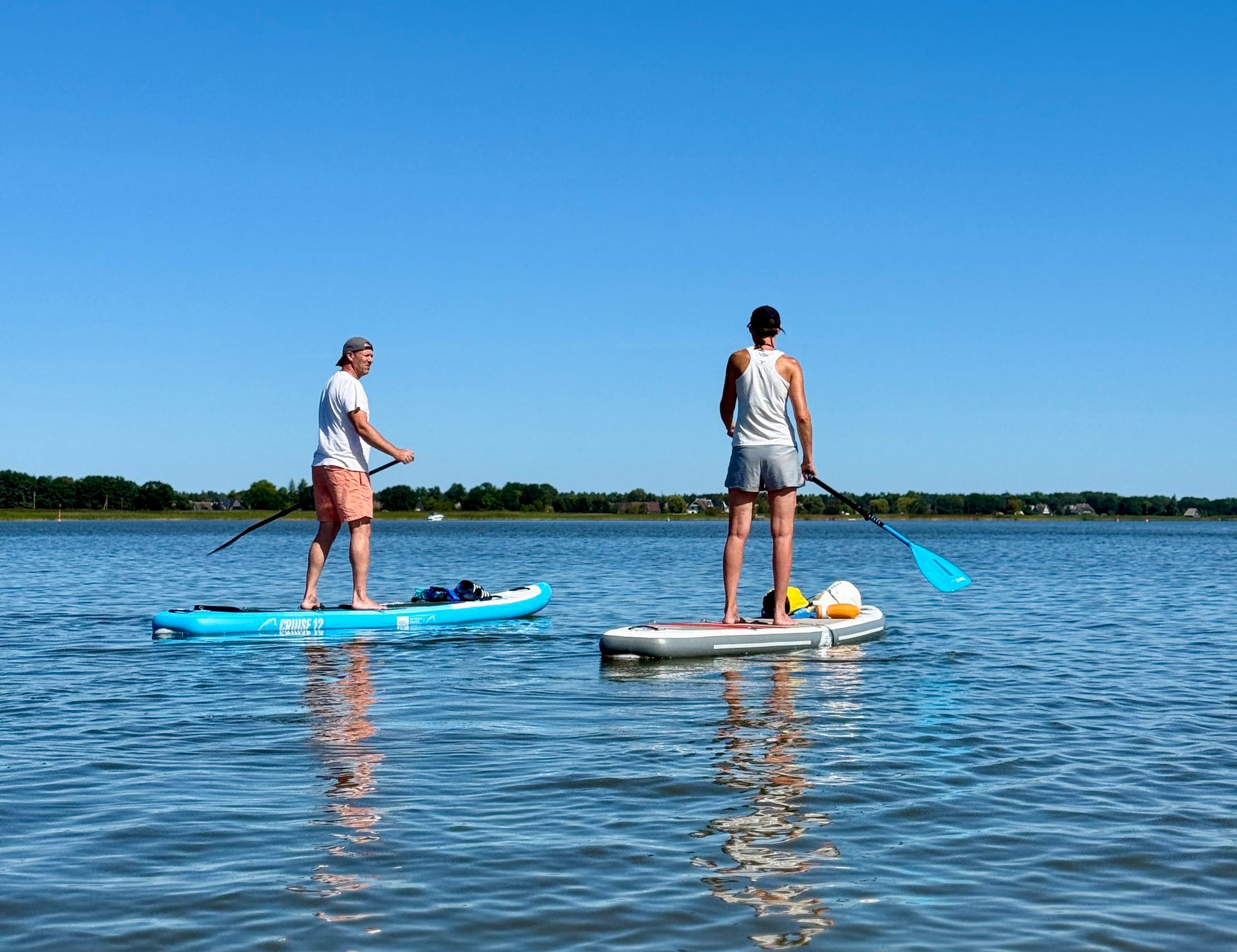 Zwei Menschen paddeln mit dem Stand Up Paddle Board auf dem Bodden