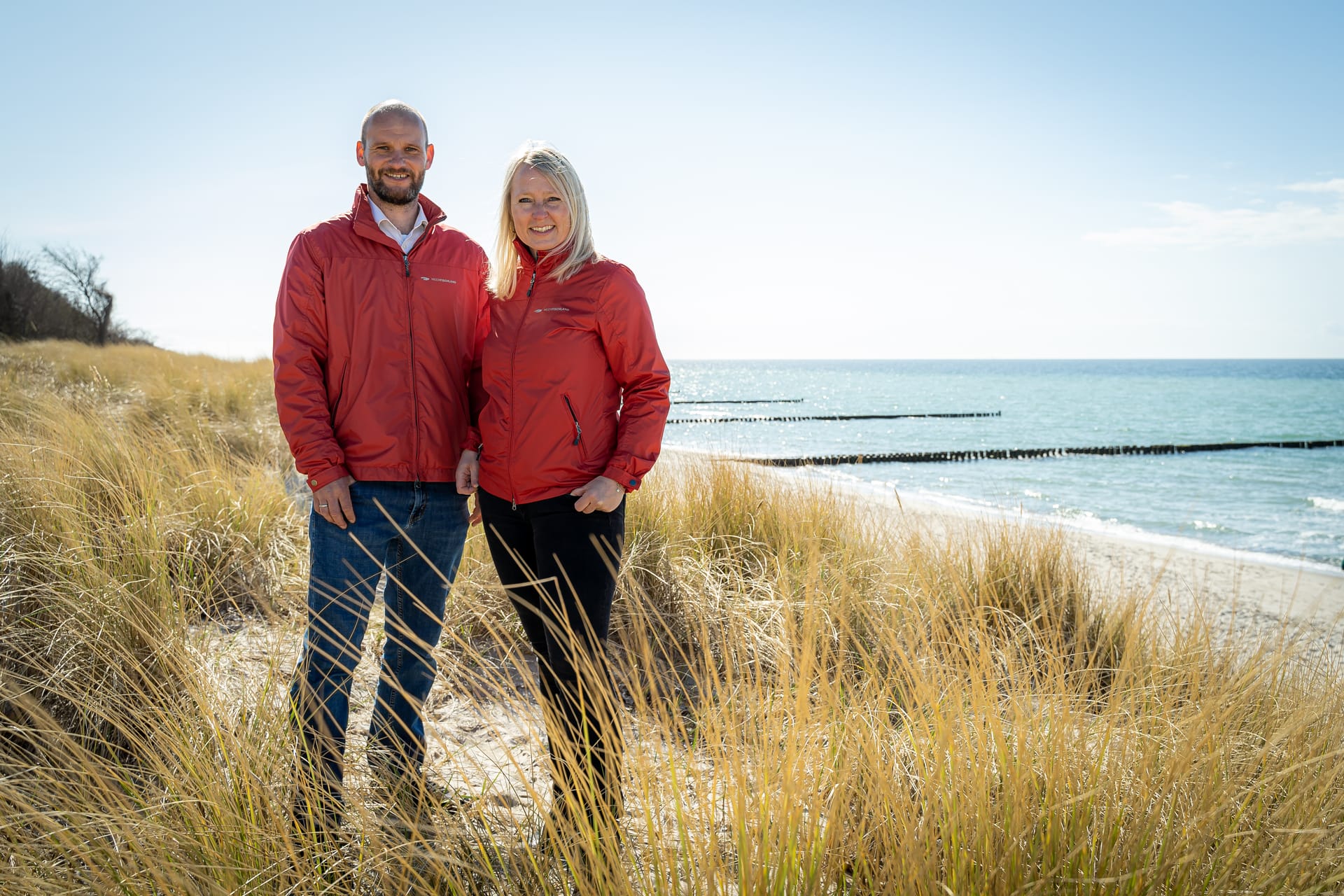 Mitarbeiter von Meerfischland stehen in Dünen