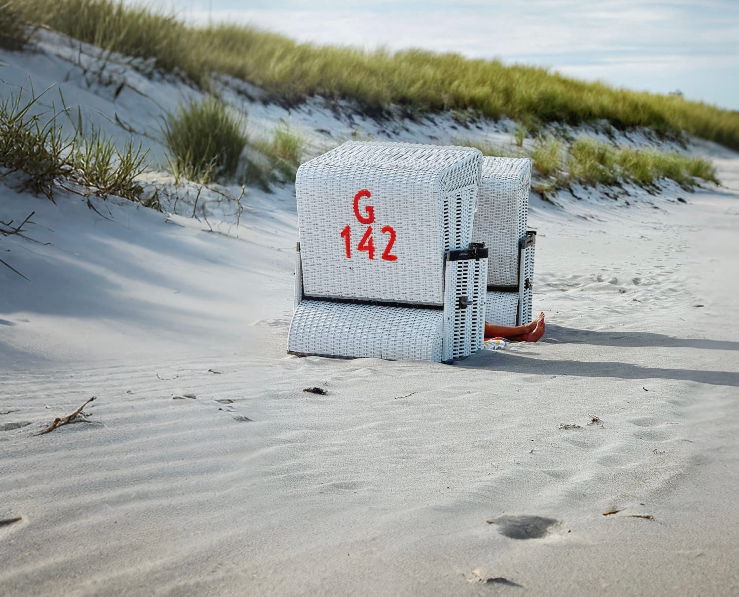 Beine gucken zwischen zwei Strandkörben hervor