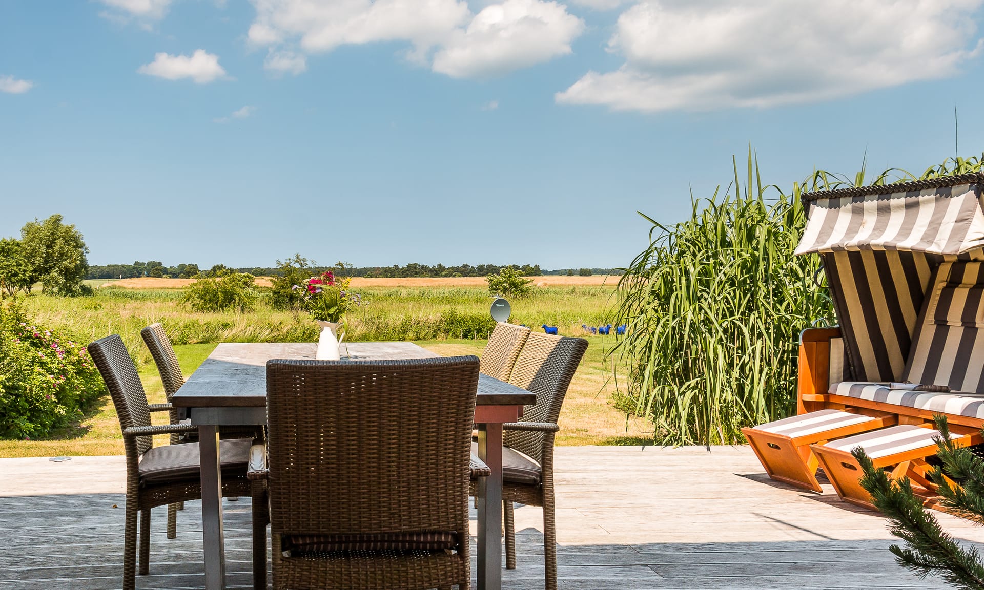 Sonnige Terrasse mit Sitzplatz und weitem Blick ins Grüne