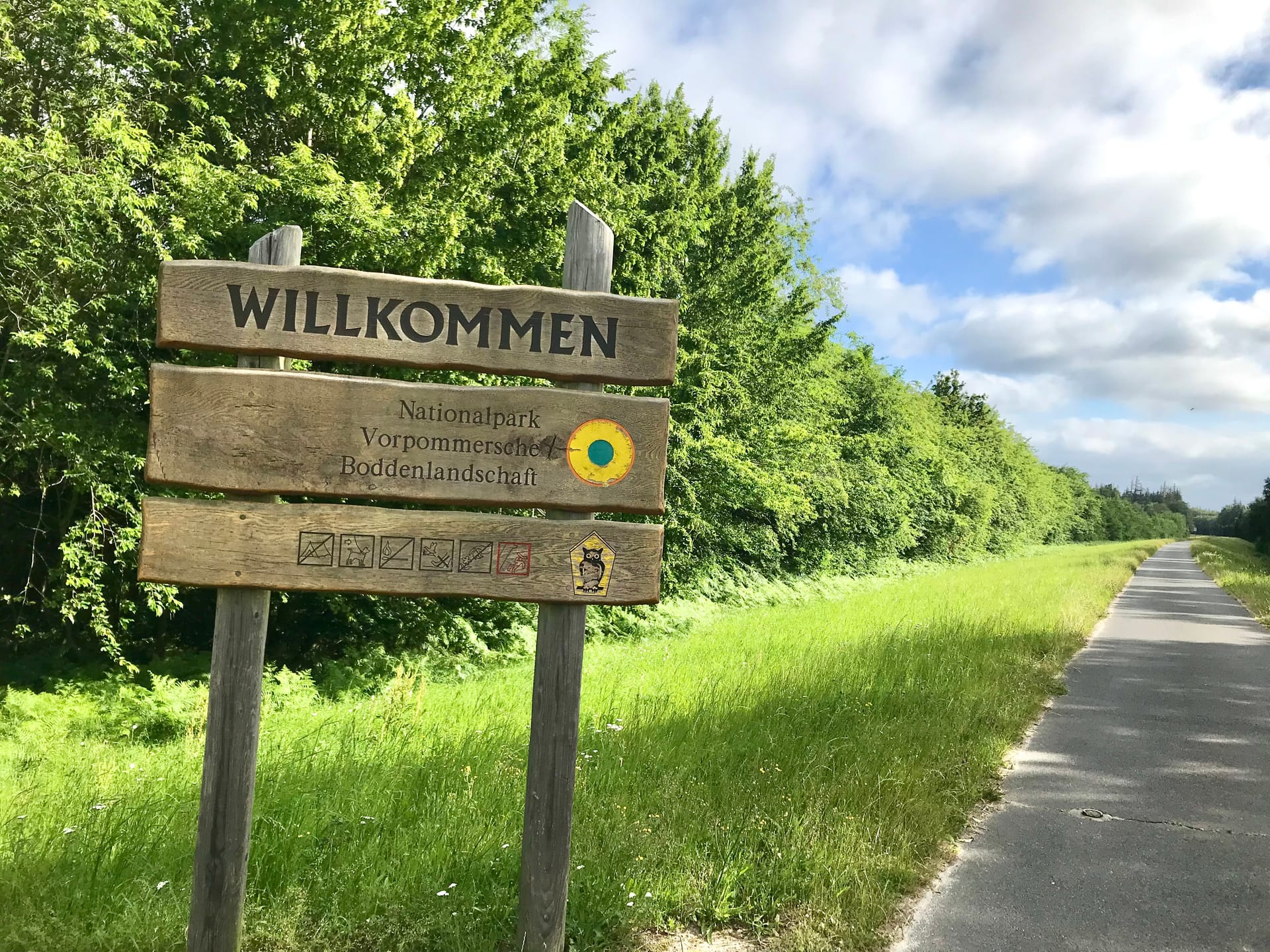 Holzschild mit Nationalparkaufschrift am Deich