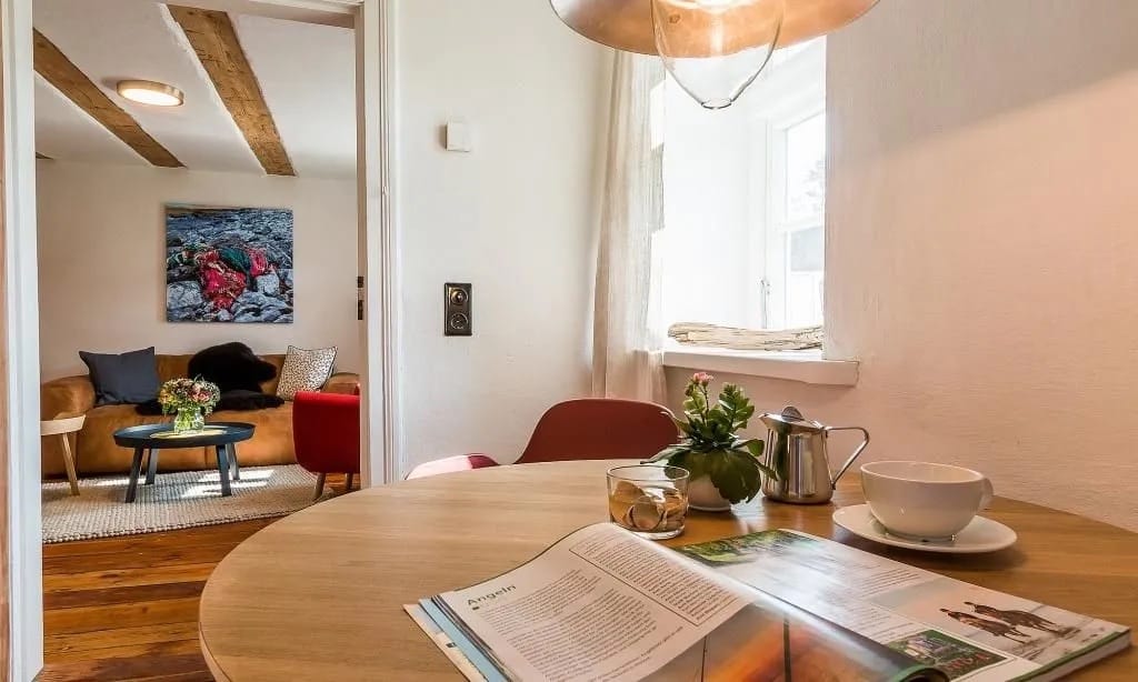 Diner am runden Tisch mit Blick ins Wohnzimmer, Magazin und Tasse.
